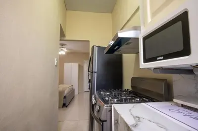 a kitchen with a stove and a microwave at Studio 3 Zona Colonial - Centro Histórico in Santo Domingo