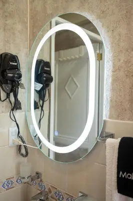a bathroom with a round mirror on the wall at Studio 3 Zona Colonial - Centro Histórico in Santo Domingo