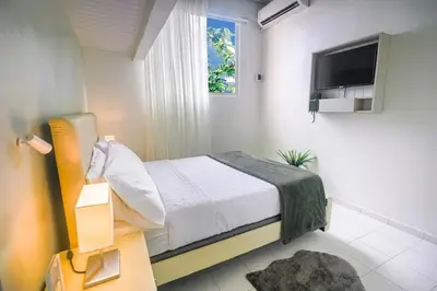 a small bedroom with a bed and a television at Estudio 2 Conde 504 at Historic Main Street in Santo Domingo