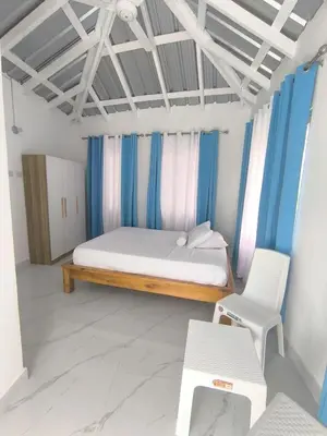 a bedroom with a bed and a chair in it at Room Vanesa in Las Terrenas