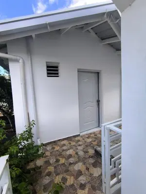 a white house with a white door and a staircase at Room Vanesa in Las Terrenas