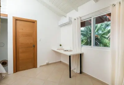 a white bathroom with a sink and a window at Casa Zelima, a fully equipped apartment in Las Terrenas