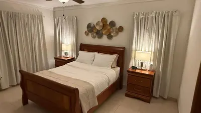 a bedroom with a bed with two nightstands and two lamps at Cozy and Beautiful, 3 Bedroom Apartment Home in Santo Domingo
