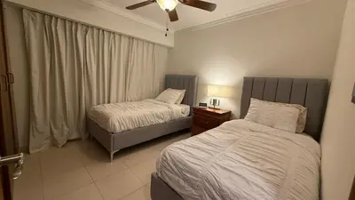 a bedroom with two beds and a ceiling fan at Cozy and Beautiful, 3 Bedroom Apartment Home in Santo Domingo