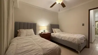 a bedroom with two beds and a ceiling fan at Cozy and Beautiful, 3 Bedroom Apartment Home in Santo Domingo