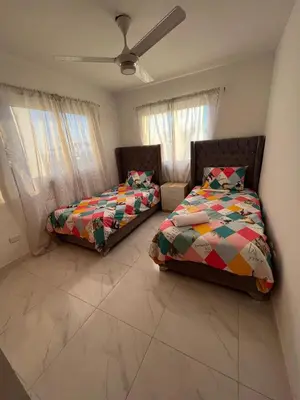 a bedroom with two beds and a ceiling fan at Ocean View Apartment in Santo Domingo Este in La Viva