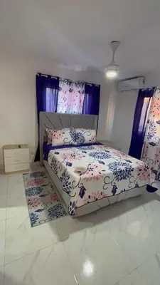 a bedroom with a bed with purple curtains at Ocean View Apartment in Santo Domingo Este in La Viva