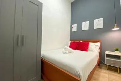 a bedroom with a bed with red and white pillows at SDQ Colonial Zone an great find in Santo Domingo