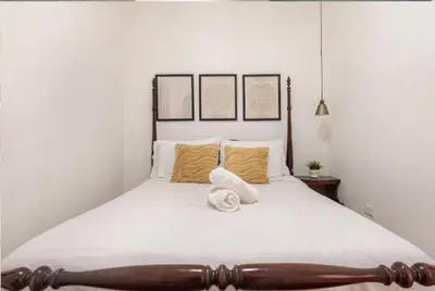 a bedroom with a large white bed with yellow pillows at SDQ Colonial Zone an great find in Santo Domingo