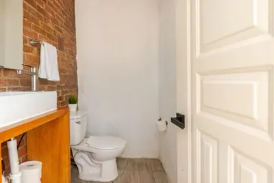 a bathroom with a white toilet and a sink at SDQ Colonial Zone an great find in Santo Domingo