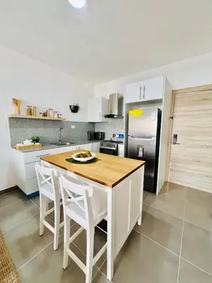 a kitchen with a table and a refrigerator at Caribbean dream in Punta Cana in Colorado