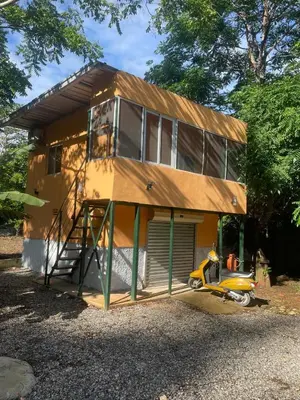 a house with a scooter parked in front of it at Bargain Beach Getaway in Las Terrenas