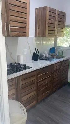 a kitchen with wooden cabinets and a stove top oven at Bargain Beach Getaway in Las Terrenas