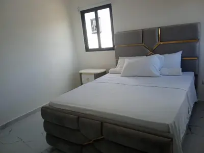 a bedroom with a large white bed with a window at Villas Reynoso, Near La Playita Beach in Las Galeras Samaná in Las Galeras