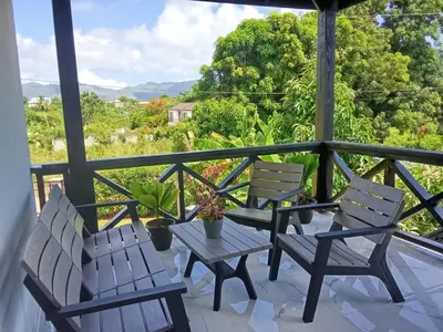 two chairs and a table on a balcony with a view at Villas Reynoso, Near La Playita Beach in Las Galeras Samaná in Las Galeras