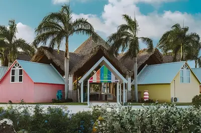 a group of houses with palm trees in the background at Condominio privado con piscina, cerca de la playa in Punta Cana