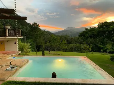 a large swimming pool with a view of a mountain at Villa del Pino en Quintas del Bosque in Jarabacoa