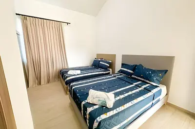 a bedroom with a bed with blue and white pillows at Cana Pearl Fase I y II in Punta Cana