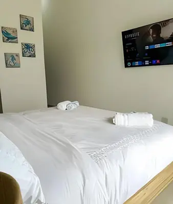 a white bed with a tv on the wall at Cana Pearl Fase I y II in Punta Cana