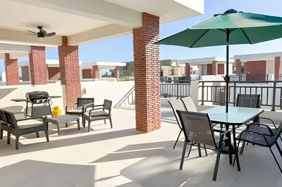 a patio with tables and chairs and an umbrella at Coral Village II in Punta Cana