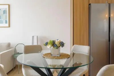 a glass table with a vase of flowers on it at Escapada caribena: Piscina y cerca de la playa in Punta Cana
