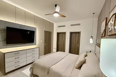 a bedroom with a large bed and a flat screen tv at Alojamientos en Coral Bay II Cerca del Hard Rock Hotel Punta Cana in Punta Cana