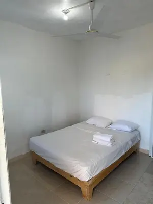 a bed in a room with two towels on it at Aparta El Mundo in Punta Cana