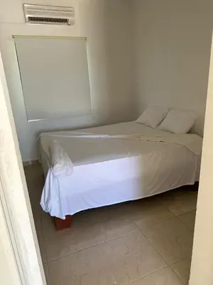 a white bed in a room with a window at Aparta El Mundo in Punta Cana