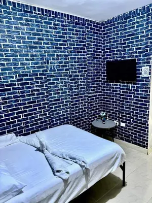 a bedroom with a blue brick wall and a bed at Aparta El Mundo in Punta Cana