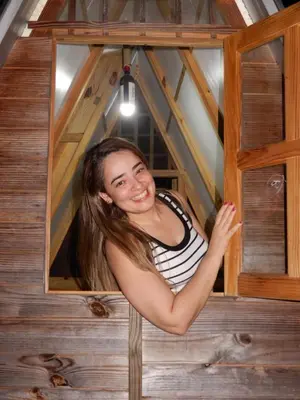 a woman standing in a window in a tree house at Eco Camping Jarabacoa in Jarabacoa
