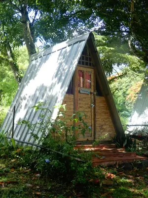 a small wooden house with a tin roof at Eco Camping Jarabacoa in Jarabacoa