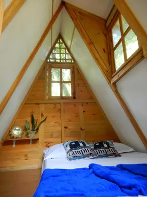 a bedroom in a log cabin with a bed at Eco Camping Jarabacoa in Jarabacoa