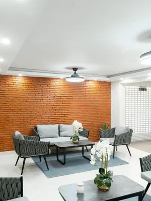 a living room with a couch and a brick wall at Ocean Winds Hotel in San Felipe de Puerto Plata