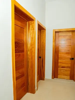 an empty room with two wooden doors at Ocean Winds Hotel in San Felipe de Puerto Plata