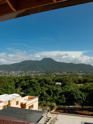 a view of the mountains from the roof of a building at Ocean Winds Hotel in San Felipe de Puerto Plata