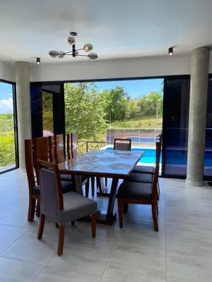 a dining room with a wooden table and chairs at Villa Tula in Sosúa