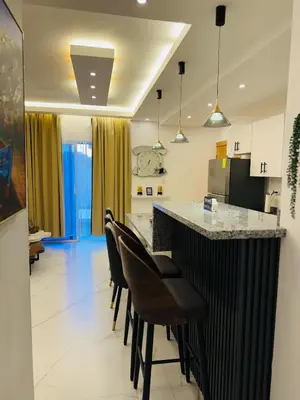 a kitchen with a black and white counter and chairs at Residencial mar azul Bayahibe in Bayahibe