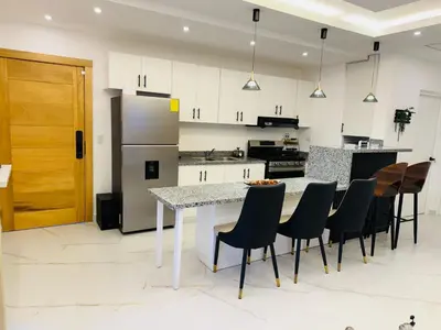 a kitchen with a table and chairs and a refrigerator at Residencial mar azul Bayahibe in Bayahibe