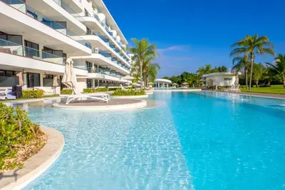 a swimming pool in front of a building at Comfy Retreat Balcony Grill Pool in Punta Cana