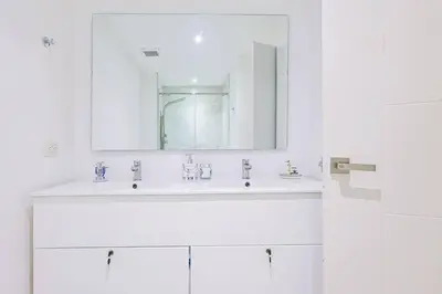a white bathroom with a sink and a mirror at Comfy Retreat Balcony Grill Pool in Punta Cana
