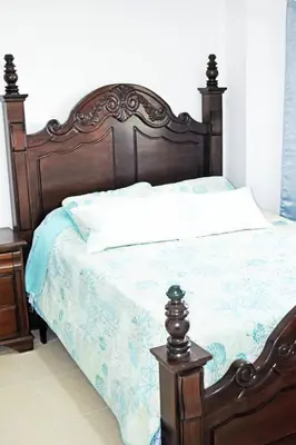 a bedroom with a wooden bed with a wooden frame at Best location Big 3 Bdrs, Fully Stocked and A/C in Santo Domingo