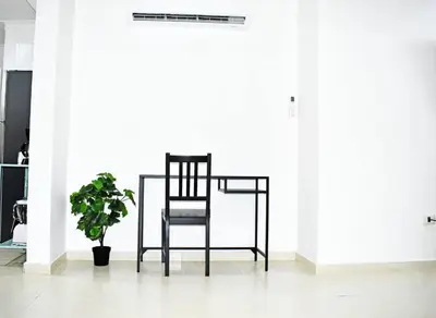 a black chair in a room with a plant at Best location Big 3 Bdrs, Fully Stocked and A/C in Santo Domingo