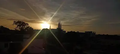 a sunset over a city with the sun in the sky at Apartamento en Residencial Los Pinos Cotui in Cotuí