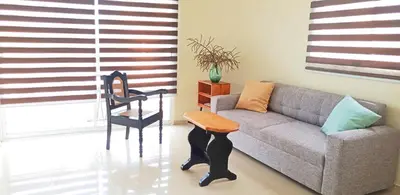 a living room with a couch and a chair at Apartamento en Residencial Los Pinos Cotui in Cotuí