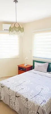 a bedroom with a large bed and a chandelier at Apartamento en Residencial Los Pinos Cotui in Cotuí