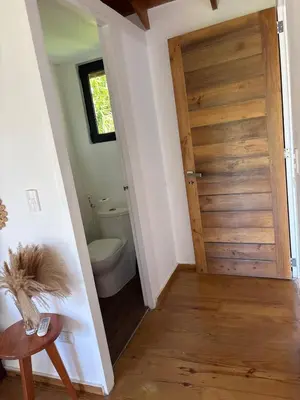 a bathroom with a wooden door and a toilet at Tropical Bliss Retreat in Las Terrenas