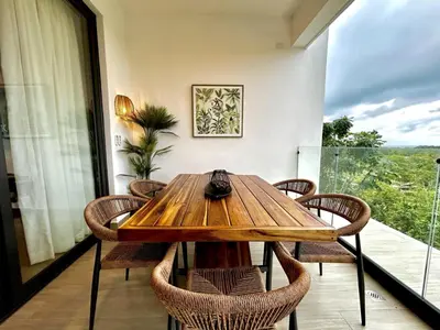 a dining room with a wooden table and chairs at ALL-NEW Modern and Stylish Apartment with Rooftop Infinity Pool in Las Terrenas