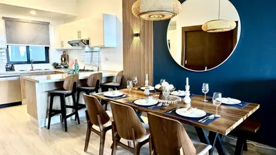 a dining room with a table and a mirror at ALL-NEW Modern and Stylish Apartment with Rooftop Infinity Pool in Las Terrenas