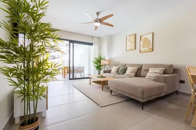 a living room with a couch and a table at Brand New 2BR Stylish Apartment in the Heart of Punta Cana, Gardenia Gated Community in Punta Cana