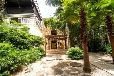 a palm tree in front of a house at Espectacular Apto en Casa de Campo Los Altos 3 in La Romana